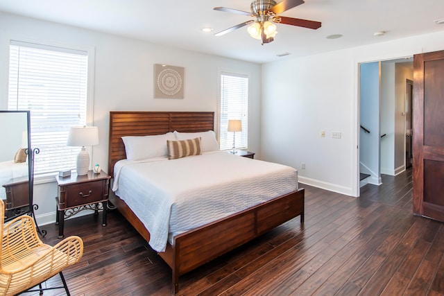 bedroom featuring multiple windows, dark hardwood / wood-style floors, and ceiling fan