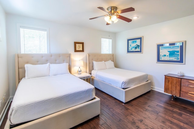 bedroom with dark hardwood / wood-style flooring, ceiling fan, and multiple windows