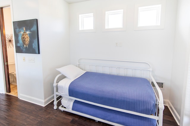 bedroom with dark hardwood / wood-style floors