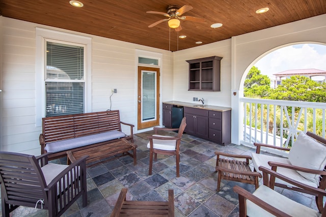 view of patio with ceiling fan, an outdoor living space, and sink