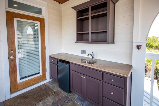 exterior space featuring a wealth of natural light, sink, and dark tile floors