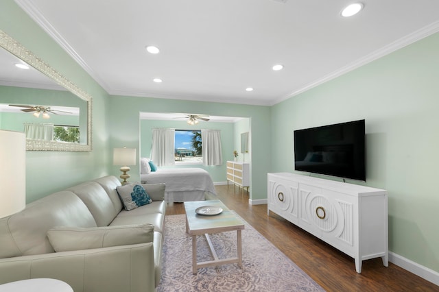 living room with ornamental molding, ceiling fan, and dark wood-type flooring