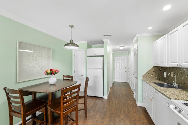 dining area with ornamental molding, dark hardwood / wood-style flooring, and sink