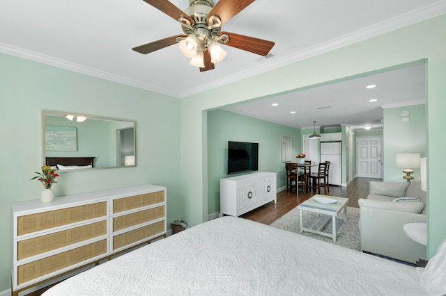 bedroom featuring white refrigerator, ceiling fan, crown molding, and dark wood-type flooring