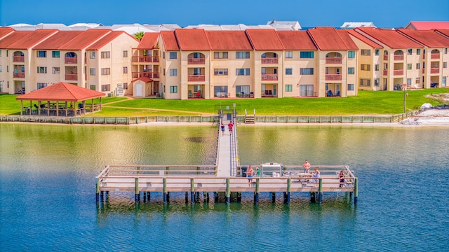 view of dock with a lawn, a gazebo, and a water view