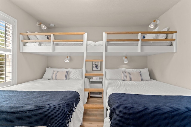 bedroom with multiple windows and hardwood / wood-style flooring