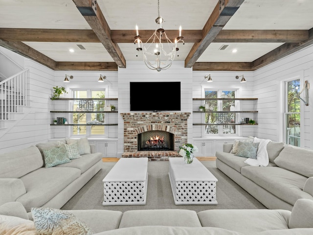 living room featuring an inviting chandelier, visible vents, a fireplace, and a wealth of natural light