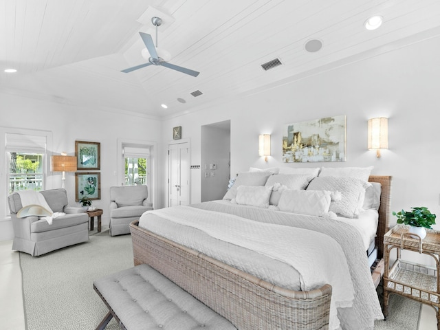 carpeted bedroom featuring lofted ceiling, visible vents, multiple windows, and a ceiling fan