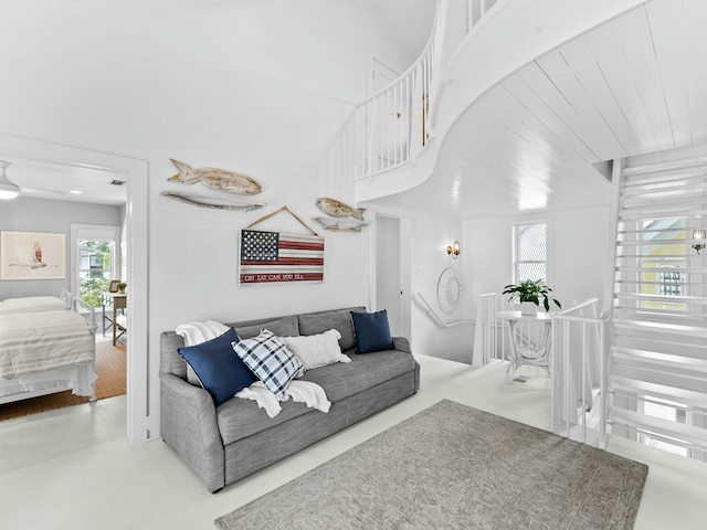 living area featuring a high ceiling, wood ceiling, and ceiling fan