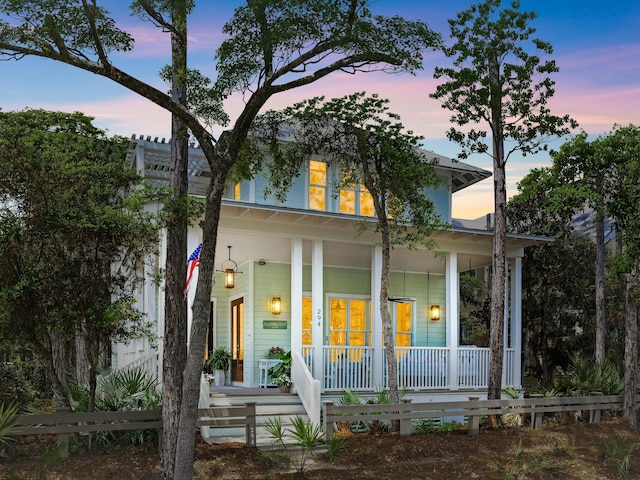 view of front of property with a porch and fence