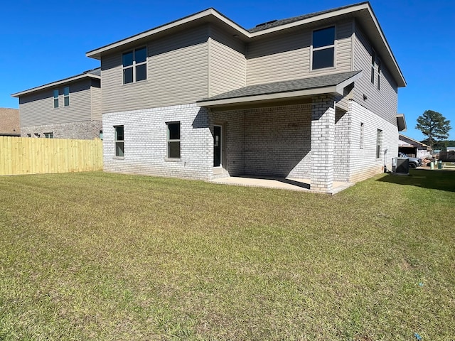 back of house featuring a patio area and a lawn