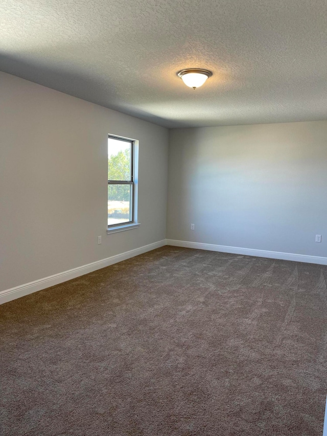 carpeted spare room with a textured ceiling