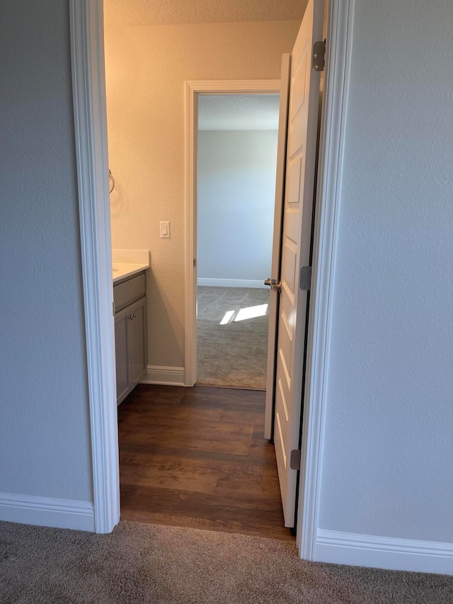 corridor with dark hardwood / wood-style flooring