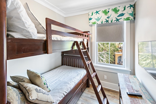 bedroom featuring crown molding and light wood-type flooring