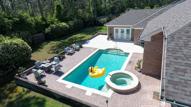 view of swimming pool featuring a patio area, an in ground hot tub, and french doors