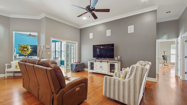 living room featuring ceiling fan, crown molding, and light hardwood / wood-style flooring