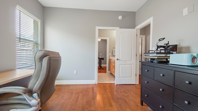 home office with light hardwood / wood-style floors