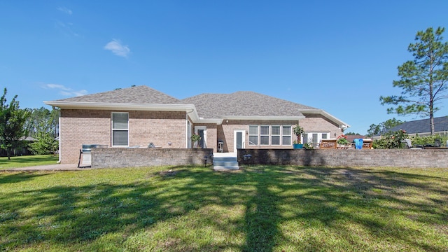 rear view of property with a lawn