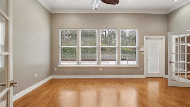 empty room featuring ceiling fan, french doors, crown molding, and light wood-type flooring