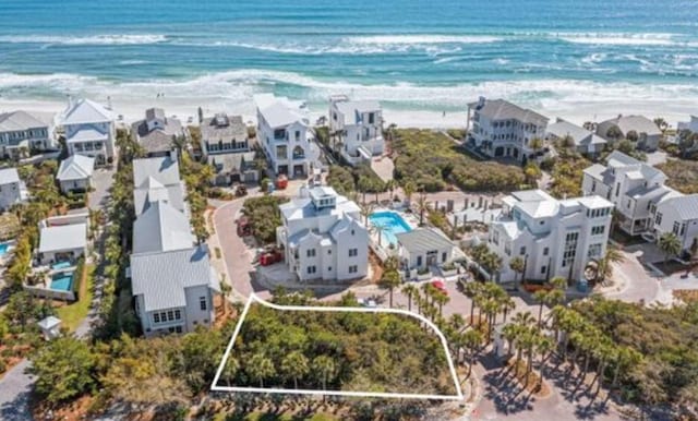 birds eye view of property with a beach view and a residential view