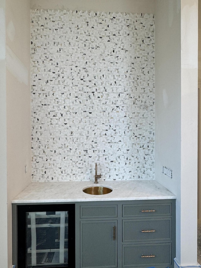 bar featuring wine cooler, decorative backsplash, a sink, and wet bar