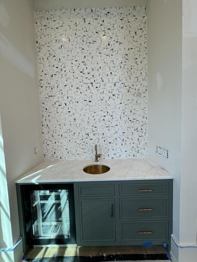 bathroom with beverage cooler, a sink, and decorative backsplash