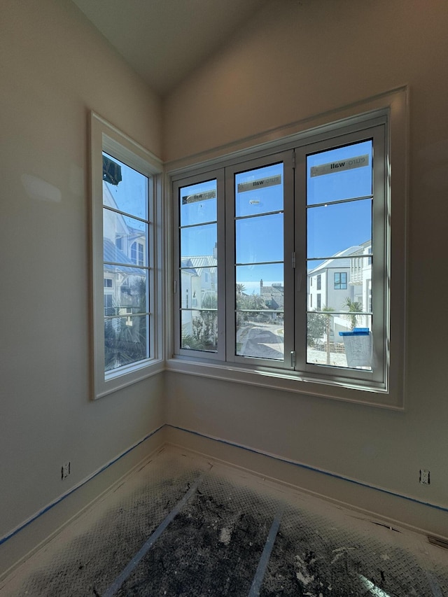 empty room featuring lofted ceiling