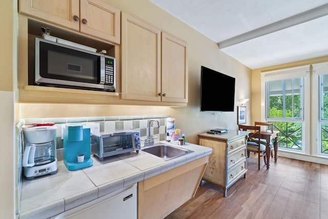 kitchen with light brown cabinets, tile countertops, hardwood / wood-style floors, and sink