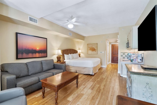 bedroom with light hardwood / wood-style floors and ceiling fan