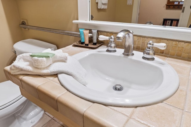 details with toilet, tile flooring, and sink