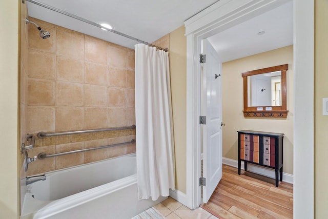 bathroom featuring wood-type flooring and shower / tub combo