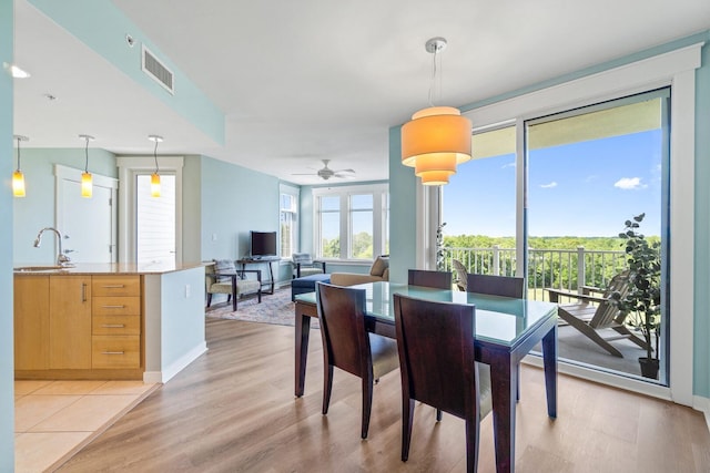 dining area featuring sink, ceiling fan, and light tile floors