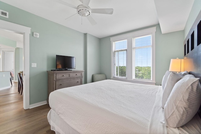 bedroom with dark hardwood / wood-style flooring and ceiling fan