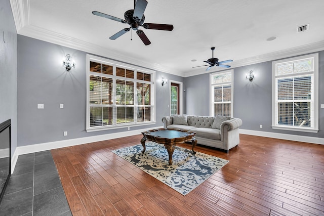 living room featuring ornamental molding, ceiling fan, a wealth of natural light, and dark hardwood / wood-style floors