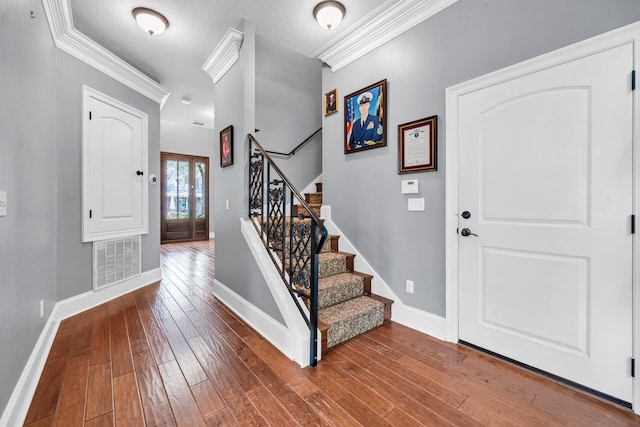 foyer with dark wood-type flooring and ornamental molding