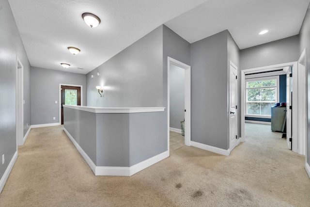 hallway featuring light colored carpet