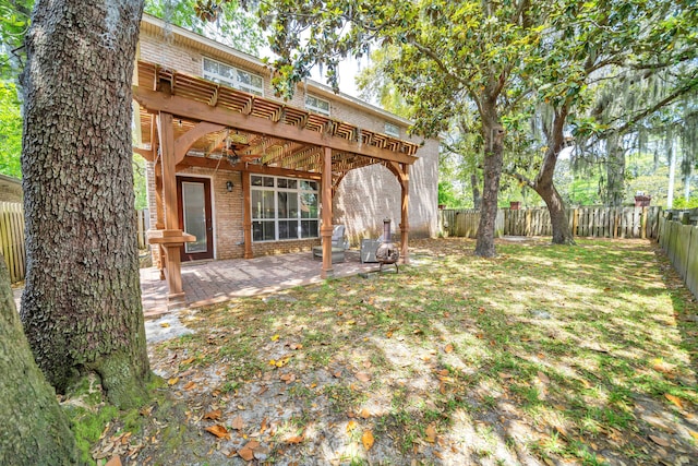 view of yard featuring ceiling fan and a patio