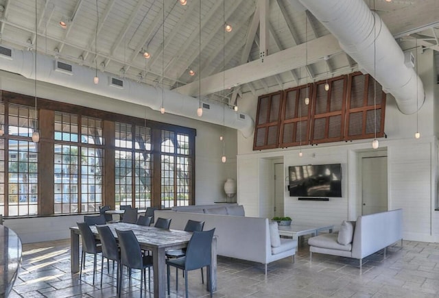 dining area featuring high vaulted ceiling