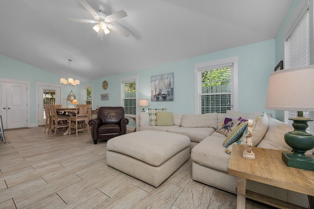 living room with ceiling fan with notable chandelier and vaulted ceiling