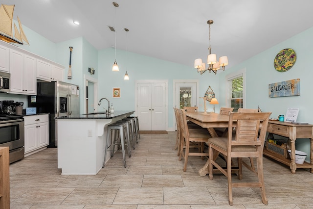 tiled dining area with sink, high vaulted ceiling, and an inviting chandelier