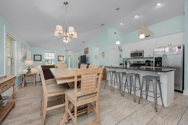 dining area with high vaulted ceiling, a chandelier, and light tile floors