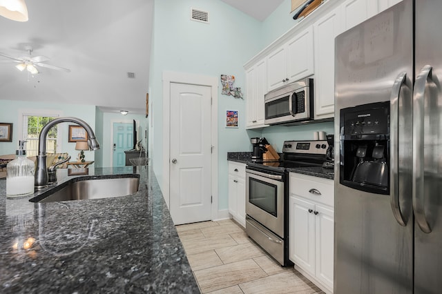 kitchen with appliances with stainless steel finishes, ceiling fan, white cabinets, sink, and light tile floors