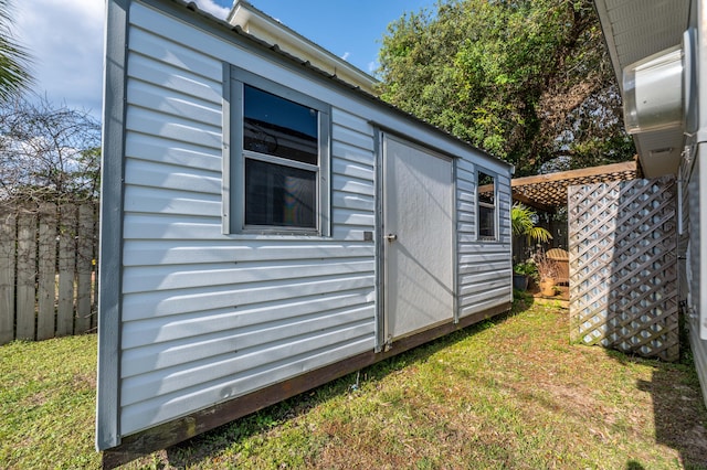 view of side of property featuring a storage shed and a lawn