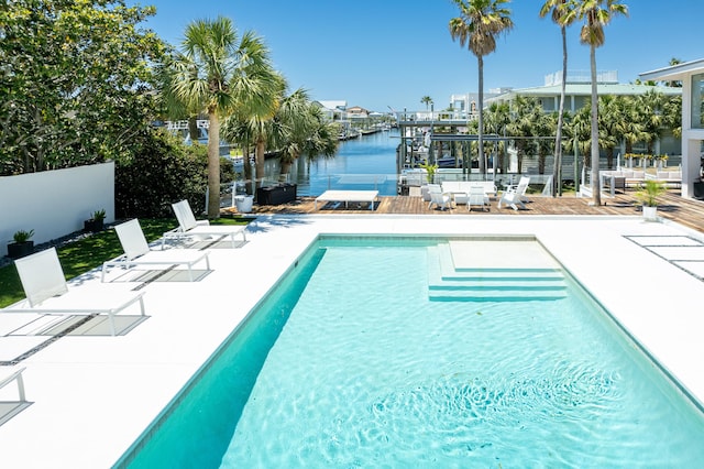 view of swimming pool with a water view, a patio area, fence, and a fenced in pool