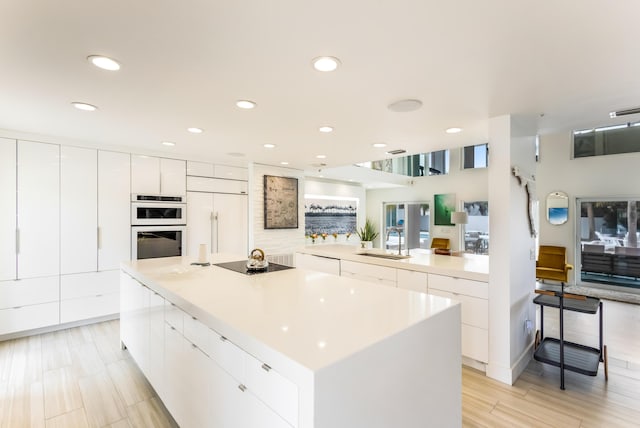 kitchen featuring paneled built in refrigerator, modern cabinets, and a sink