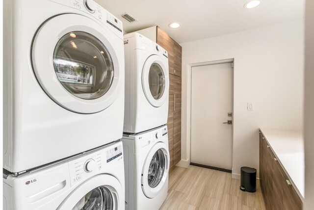 laundry room with stacked washer and dryer, laundry area, visible vents, baseboards, and recessed lighting