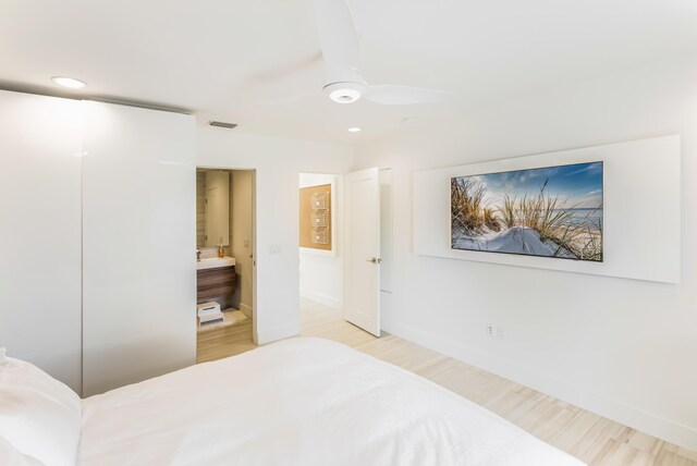 bedroom with ensuite bathroom, recessed lighting, wood finished floors, visible vents, and baseboards