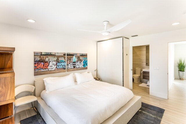 bedroom featuring baseboards, a ceiling fan, ensuite bathroom, light wood-style floors, and recessed lighting