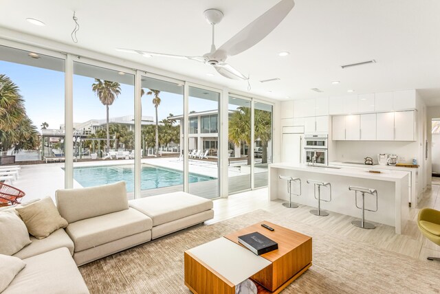 living area featuring a wall of windows, recessed lighting, visible vents, and a ceiling fan