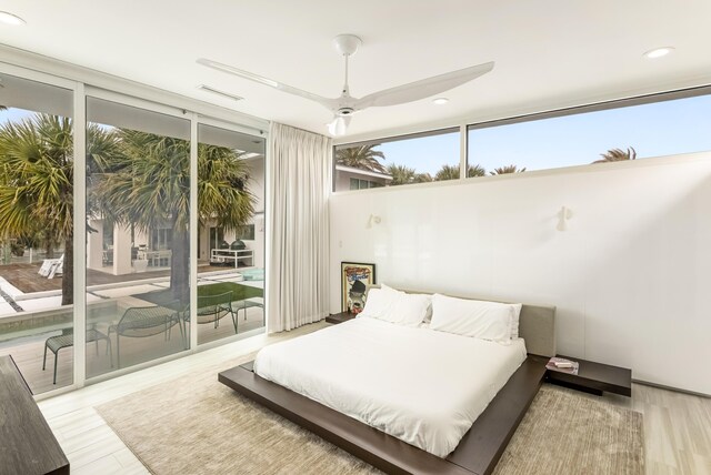 bedroom featuring expansive windows, access to outside, visible vents, and wood finished floors